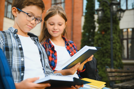 Happy schoolchildren near the school. A boy and a girl are primary school students. School friendship.の写真素材
