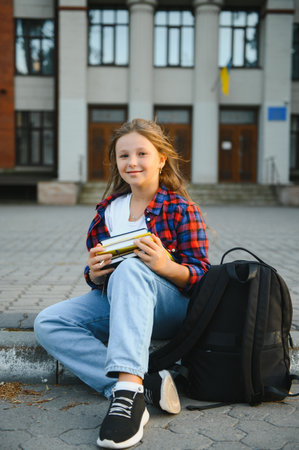 Beautiful schoolgirl with a backpack and books. Back to school.の写真素材