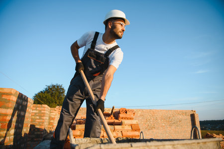 Construction worker in uniform and safety equipment have job on building. Industrial theme.の写真素材