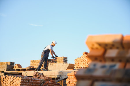 Construction worker in uniform and safety equipment have job on building.の写真素材