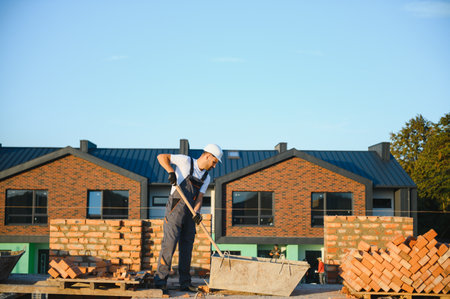 Man bricklayer installing bricks on construction site.