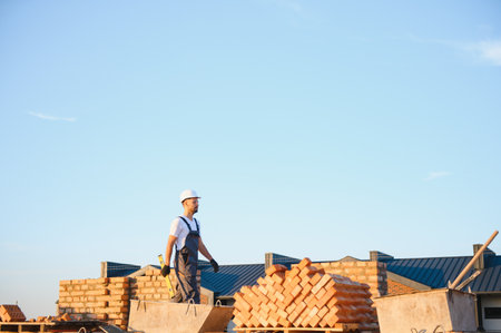 Construction worker man in work clothes and a construction helmet. Portrait of positive male builder...