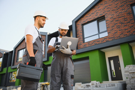Building inspector and builder inspecting new cottage complex.