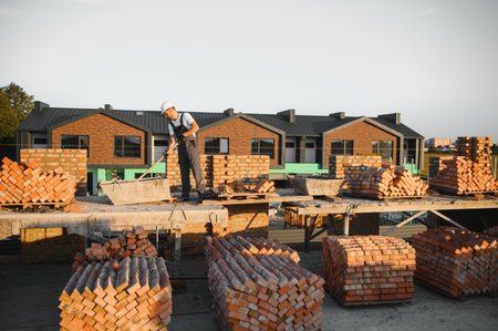 Man bricklayer installing bricks on construction site.の写真素材