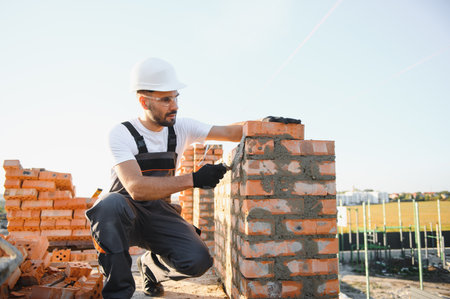 Construction worker in uniform and safety equipment have job on building.の写真素材