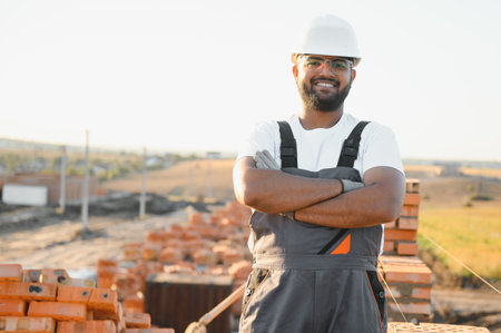 Indian Construction worker in uniform and safety equipment have job on building.の写真素材