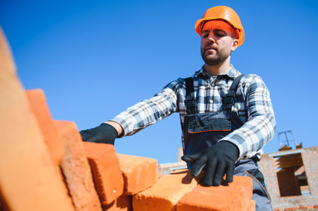 Construction worker in uniform and safety equipment have job on building.の写真素材