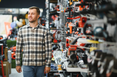 A male buyer chooses power tools in a hardware store. A large selection of tools.の写真素材