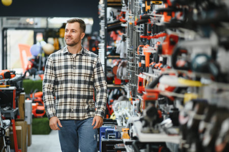A male buyer chooses power tools in a hardware store. A large selection of tools.の写真素材