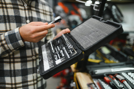 A male buyer chooses a toolbox in a hardware store. A large selection of toolsの写真素材