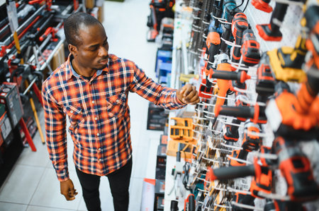 A African American man chooses a power tool in a hardware store.の写真素材
