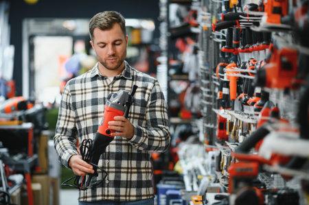 A man in a hardware store choosing a tool.の写真素材