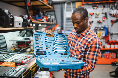 African American male buyer chooses a toolbox in a hardware store. A large selection of tools.の写真素材