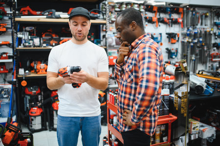The seller helps the buyer choose a screwdriver in a hardware store