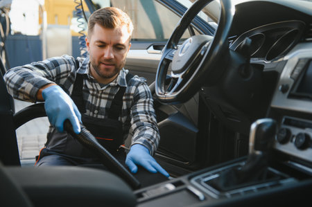 Car detailing and car care concept - Professional using steam vacuum for draining stains.の写真素材