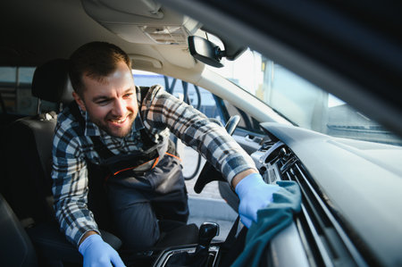 Feeling happy to be doing an excellent job at my job at the car wash. Portrait of a man while sitting inside a customer vehicle.の写真素材