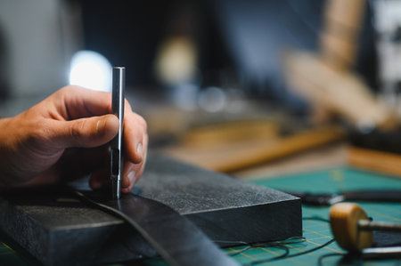 leather craftsman is carefully to make a leather product for a customer. Leather craftsman concept.の写真素材