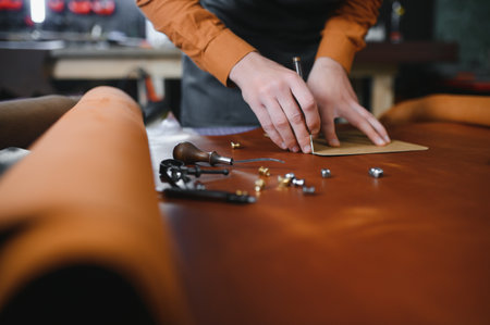 leather craftsman is carefully to make a leather product for a customer. Leather craftsman concept.