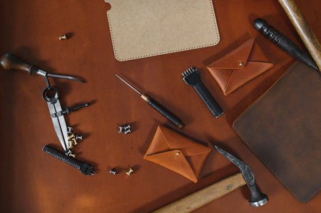 Banner tailor industry craftsman. Leather rolls and tools for handmade craft in workshop.の写真素材