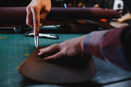 leather craftsman is carefully to make a leather product for a customer. Leather craftsman concept.
