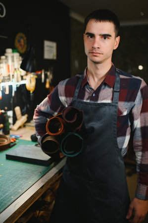 Portrait of handsome tanner man at work, small business, authentic workshop, indoors. leather goods. brownの写真素材