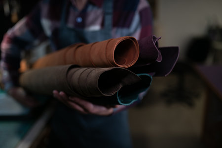 leather craftsman is carefully to make a leather product for a customer. Leather craftsman concept.の写真素材