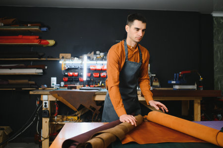 Banner tailor industry craftsman. Leather rolls and tools for handmade craft in workshop.
