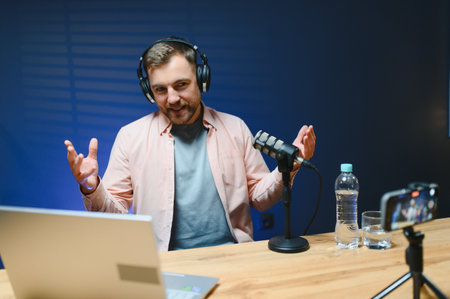 Man smiling while recording podcast in studio.