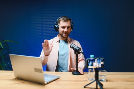 A video blogger records content in his studio. The host of the video blog is a young man who is very...