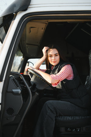 Portrait of trucker sitting in truck cabin with hands on steering wheel.の写真素材