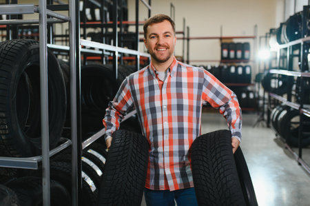man to choose tires in car store.