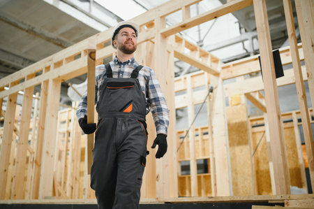 Modern modular house. A worker works on the construction of a wooden house.