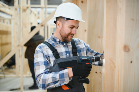 Worker carpenter assembling a modular house.の写真素材