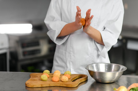 The concept of semi-finished products. Female chef cooks falafel in the kitchen.の写真素材