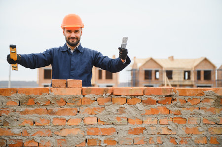 Construction worker in uniform and safety equipment have job on building. Industrial theme.