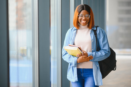 Portrait of an African-American girl student in the corridor of a modern university. The concept of higher educationの写真素材