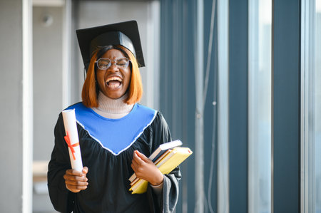 beautiful young afro american graduate holding diploma.の写真素材