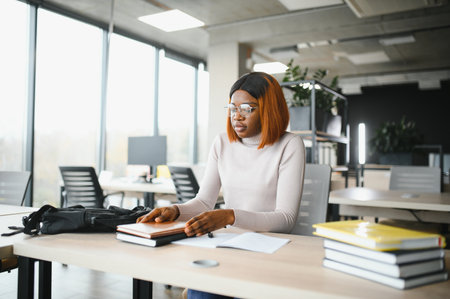 african american girl student studying at university at desk. Concept of higher education.の写真素材