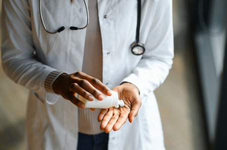 African American female doctor holding pill bottle.の写真素材