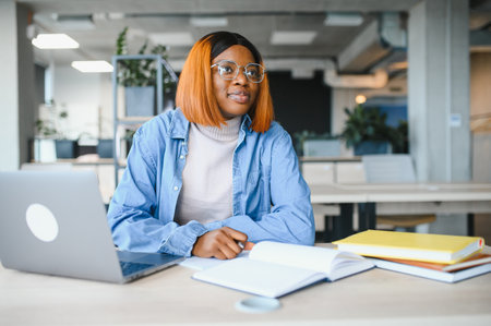 african american girl student studying at university at desk. Concept of higher education.
