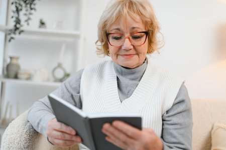 Peaceful satisfied mature woman reading book, favorite literature, senior female relaxing, enjoying...