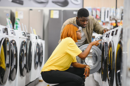 Couple choosing washing machine at electronics store.の写真素材