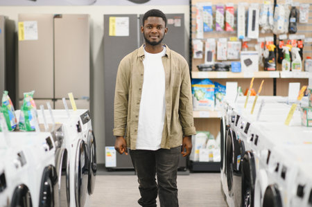 Household appliances store. An African American man buys a new modern washing machine.の写真素材