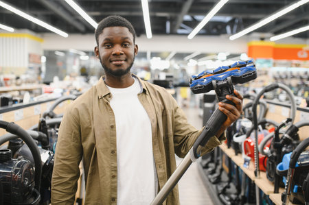 New vacuum cleaner. An African man buys a vacuum cleaner in a household goods store.の写真素材
