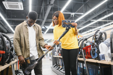 Couple choosing vacuum cleaner, electronics store.の写真素材