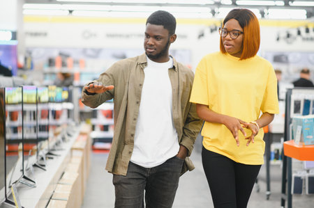 Couple looking for new TV to buy. New technologies concept.
