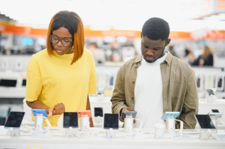 Shopping a new digital device. Happy couple buying a smartphone in store.