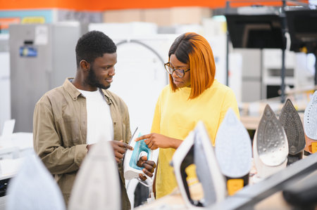 Young positive couple buying iron in hypermarket.の写真素材