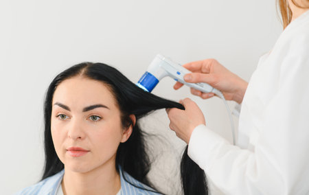 A close-up image of a person undergoing a scalp examination with a dermatoscope.の写真素材