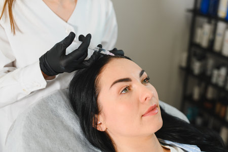 Young woman with hair problem receiving injection in clinic. Hair renewal rejuvenation pampering procedure. Cosmetology, follicles growing, botulinum treatmentの写真素材